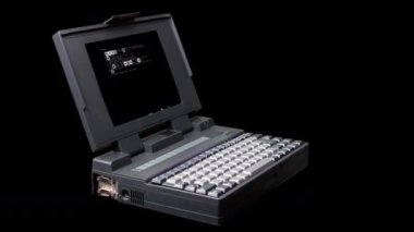 Vintage laptop spinning with code