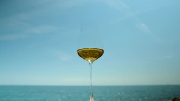 Λευκό κρασί σε ποτήρι με θέα στη θάλασσα — Αρχείο Βίντεο