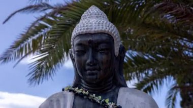 Bulutların arasından geçen bir Buda heykeli