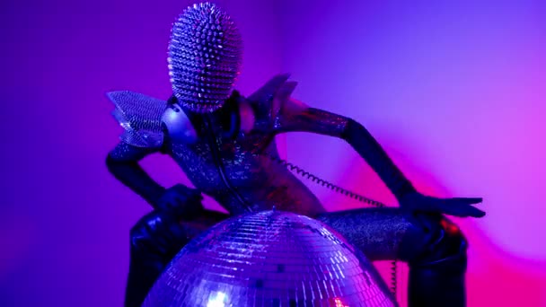 Female dancer with spiky mask against colourful background — Video