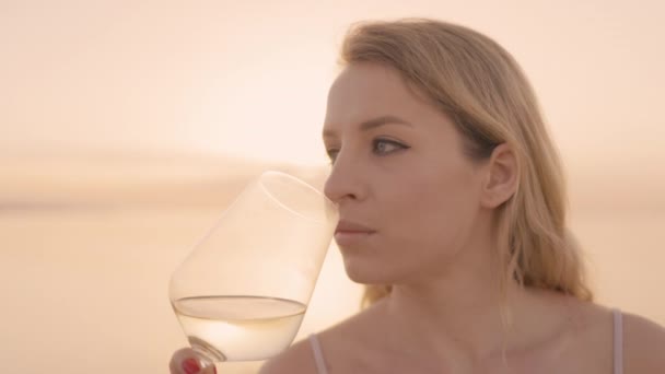 Donna in possesso di un vino in vetro contro il mare — Video Stock