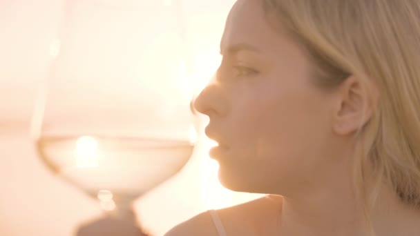 Mujer sosteniendo un vino en copa contra el mar — Vídeos de Stock