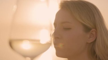 Denize karşı kadehte şarap tutan bir kadın.