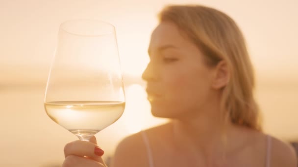 Woman holding a wine in glass against the sea — Stok Video