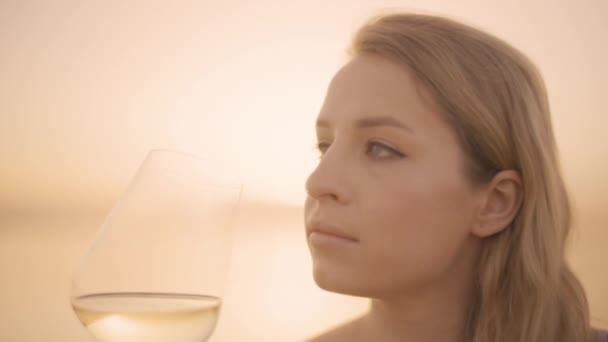 Kobieta trzymająca wino w szklance nad morzem — Wideo stockowe