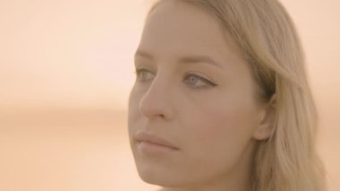 Woman headshot at sunrise by sea