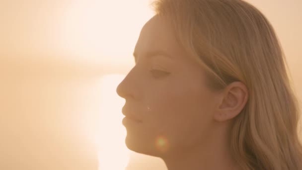 Mulher headshot ao nascer do sol pelo mar — Vídeo de Stock