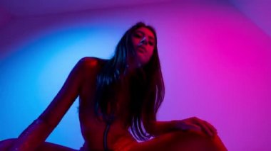 Renkli arka planda poz veren kadın dansçı