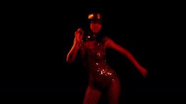 Siyah arka planda poz veren kadın dansçı