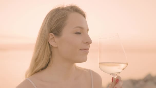 Γυναίκα που κρατά ένα κρασί σε ποτήρι ενάντια στη θάλασσα — Αρχείο Βίντεο
