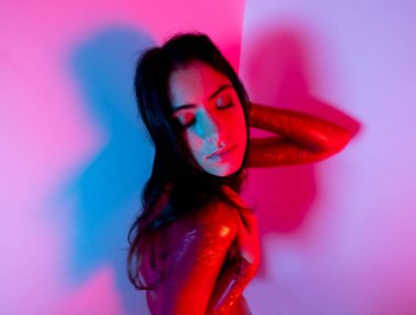 Güzel bir disko dansçısı, kırmızı kedi kostümü ve mavi ve kırmızı ışıkla.