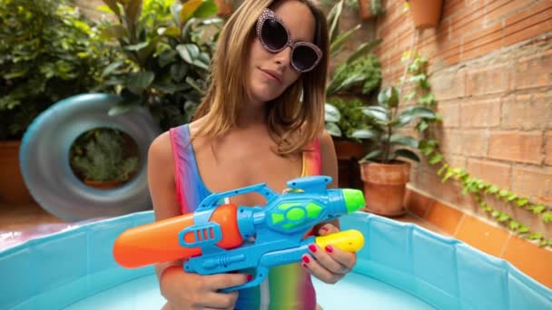 Una Mujer Bonita Bikini Con Una Pistola Agua Una Piscina — Vídeo de stock