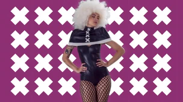 一个穿着哥特式黑色服装的漂亮的女滑稽可笑舞蹈家 背景是粉色的 有着闪光的交叉造型 — 图库视频影像