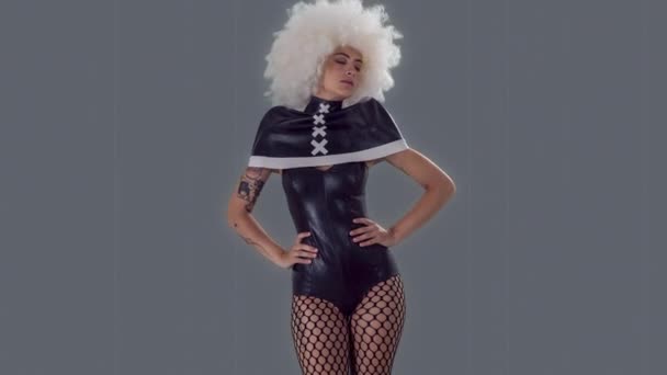 一个穿着灰色背景的哥特式黑色服装的漂亮女滑稽舞者 — 图库视频影像