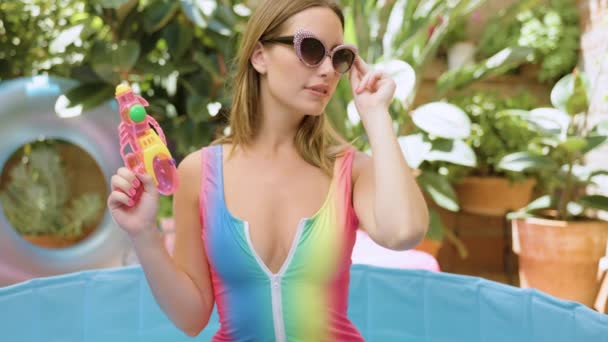 Una Bella Donna Bikini Con Una Pistola Acqua Una Piscina — Video Stock