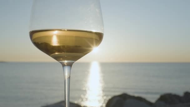 白葡萄酒酒杯日出或日落时带着闪光的大海和天空的白葡萄酒酒杯 — 图库视频影像