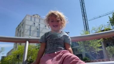 Parkta döner kavşakta dönen küçük bir kız.