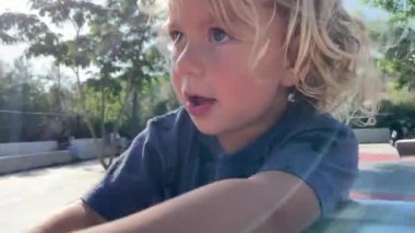 Parkta döner kavşakta dönen küçük bir kız.