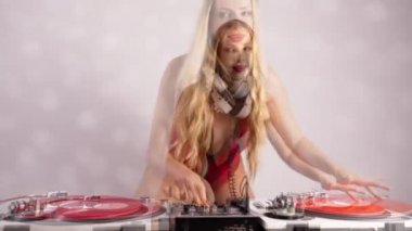 Kırmızı kıyafetli güzel bayan DJ pikaplarla oynuyor.