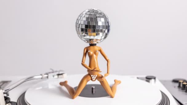 Eine Glitzernde Puppe Mit Diskokopf Tanzt Auf Einem Plattenspieler — Stockvideo