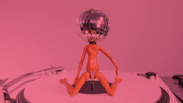 Eine Glitzernde Puppe Mit Diskokopf Tanzt Auf Einem Plattenspieler — Stockvideo