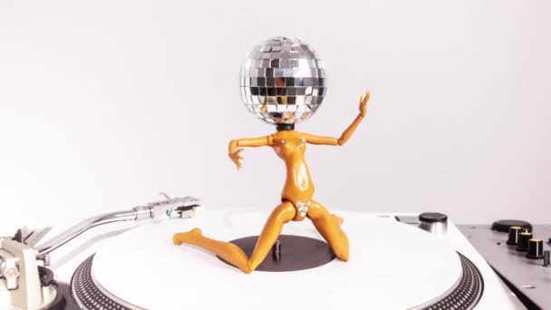 Eine Glitzernde Puppe Mit Diskokopf Tanzt Auf Einem Plattenspieler Drehend — Stockvideo