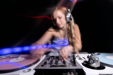 Beautiful female dj playing with turntables and overlayed light trails