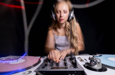 Beautiful female dj playing with turntables and overlayed light trails