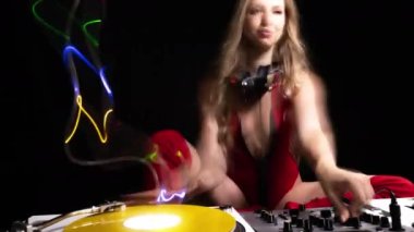 Beautiful female dj playing with turntables and overlayed light trails,