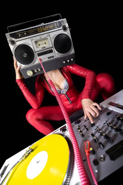 A female dj playing with a ghettoblaster for a head dancing with turntables