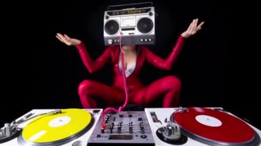 A female dj playing with a ghettoblaster for a head dancing with turntables 