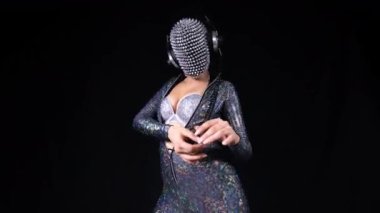 Amazing female dancer with spiked mask against black background