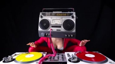 A female dj playing with a ghettoblaster for a head dancing with turntables 