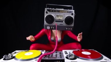 A female dj playing with a ghettoblaster for a head dancing with turntables 