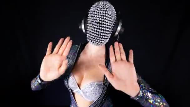 Amazing female dancer with spiked mask against black background