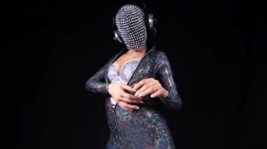 Amazing female dancer with spiked mask against black background with aged film overlayed effects