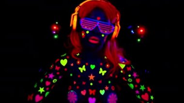 Havalı seksi dans eden kadın UV floresan giysiler ve makyaj giyiyor.