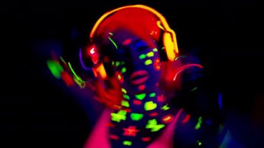 Havalı seksi dans eden kadın UV floresan giysiler ve makyaj giyiyor.