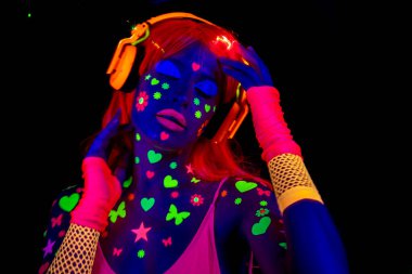 Havalı seksi dans eden kadın UV floresan giysiler ve makyaj giyiyor.