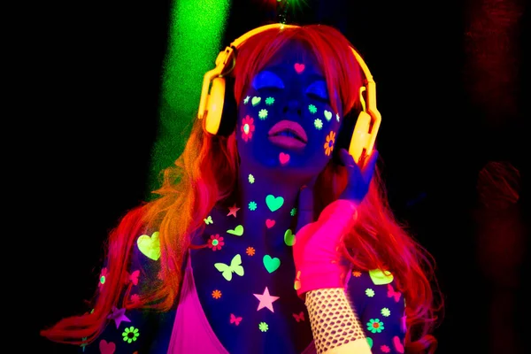 A cool sexy dancing woman wearing UV fluorescent clothing and makeup