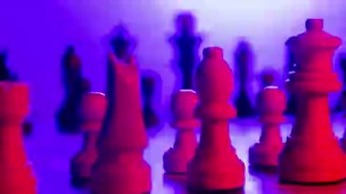 Close up of chess board against spinning with changing coloured lights 