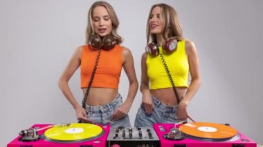 Plağın arkasında dans eden tek yumurta ikizi DJ 'ler.