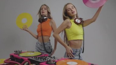 Tek yumurta ikizi DJ 'ler pikabın arkasında dans ediyor ve plaklarla kendilerini yelpazeliyorlar.