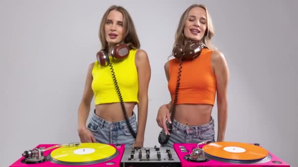 レコードターンテーブルの後ろで踊る同じ双子の女性Dj — ストック動画