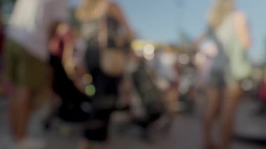 Bir kalabalığın bulanık ve yumuşak bir odak noktasında lunaparkta yürümesi.
