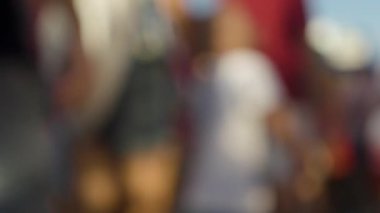 Bir kalabalığın bulanık ve yumuşak bir odak noktasında lunaparkta yürümesi.