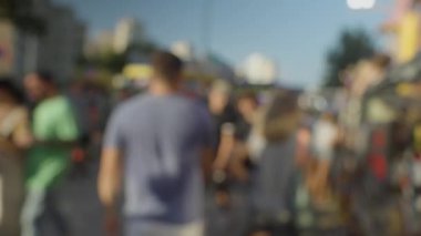 Bir kalabalığın bulanık ve yumuşak bir odak noktasında lunaparkta yürümesi.