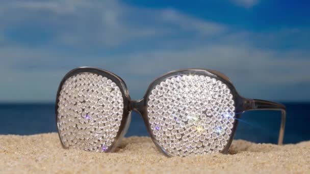 Paio Occhiali Sole Scintillanti Ricoperti Cristallo Sulla Spiaggia Con Nuvole — Video Stock