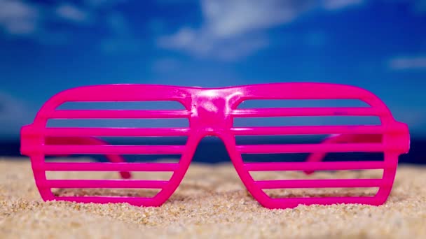 Een Roze Plastic Spleet Zonnebril Het Strand Met Passerende Wolken — Stockvideo