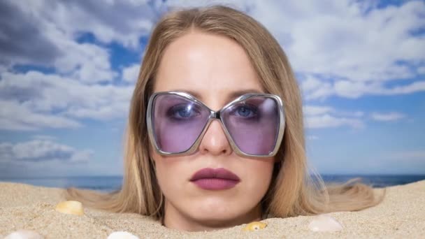 美しい女性がサングラスをかけながらビーチで頭に埋められた — ストック動画